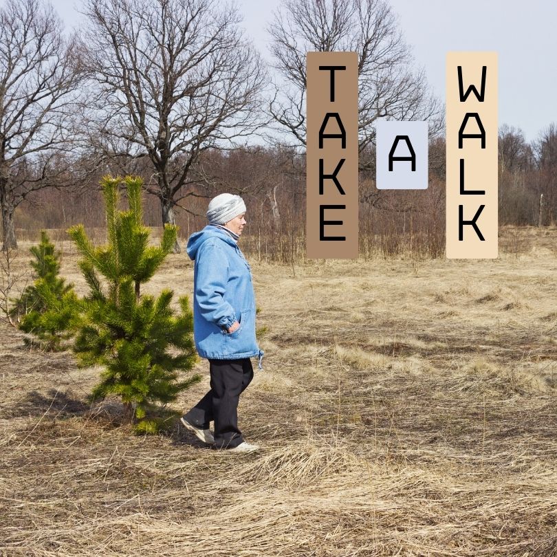 A woman taking a walk in nature to relieve stress.  Picture says Take A Walk.